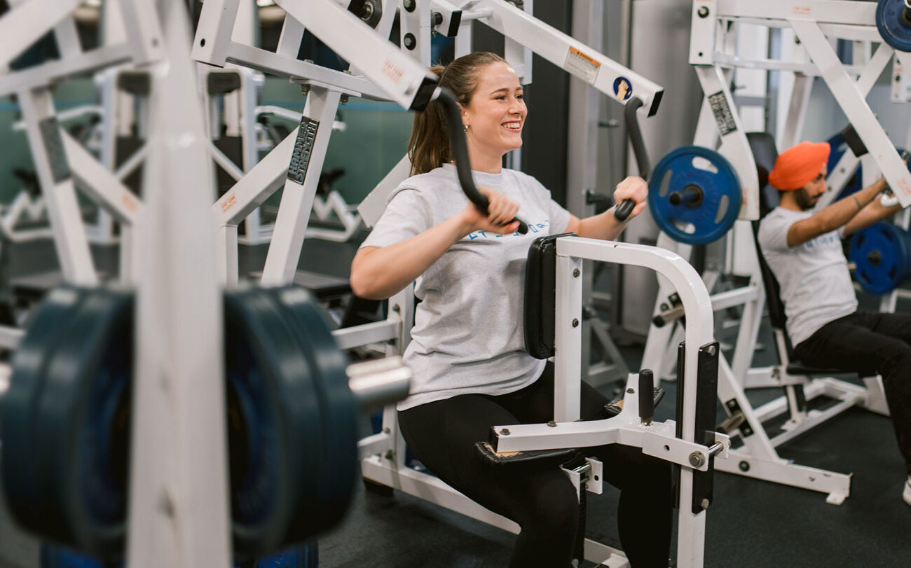Two individuals using the gym equipment